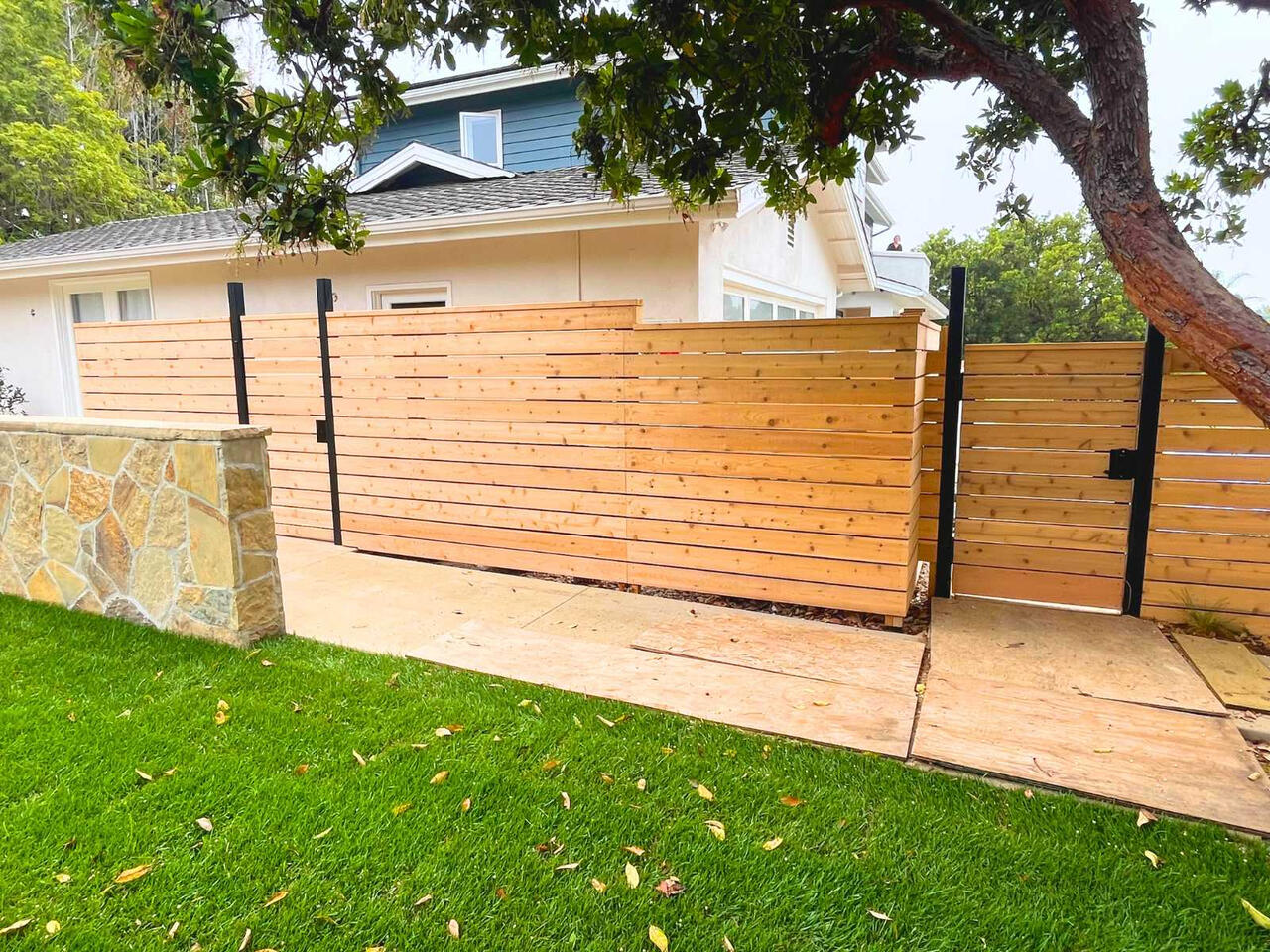A horizontal-slat fence with black posts and trim.