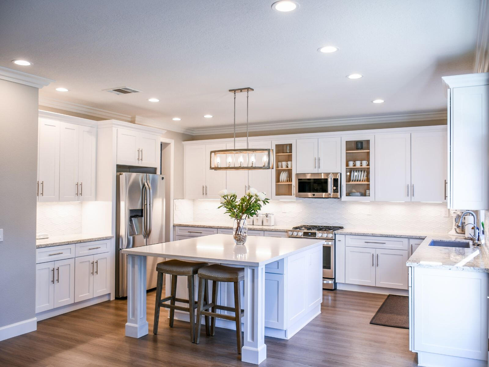 A luxury remodeled kitchen with all white trim and premium appliances and elements.